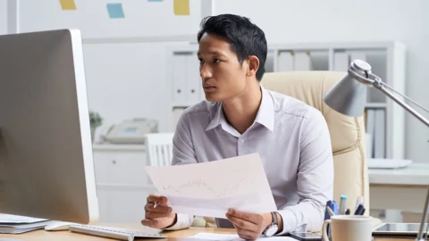 Malaysian business owner reviewing affordable web design options on laptop