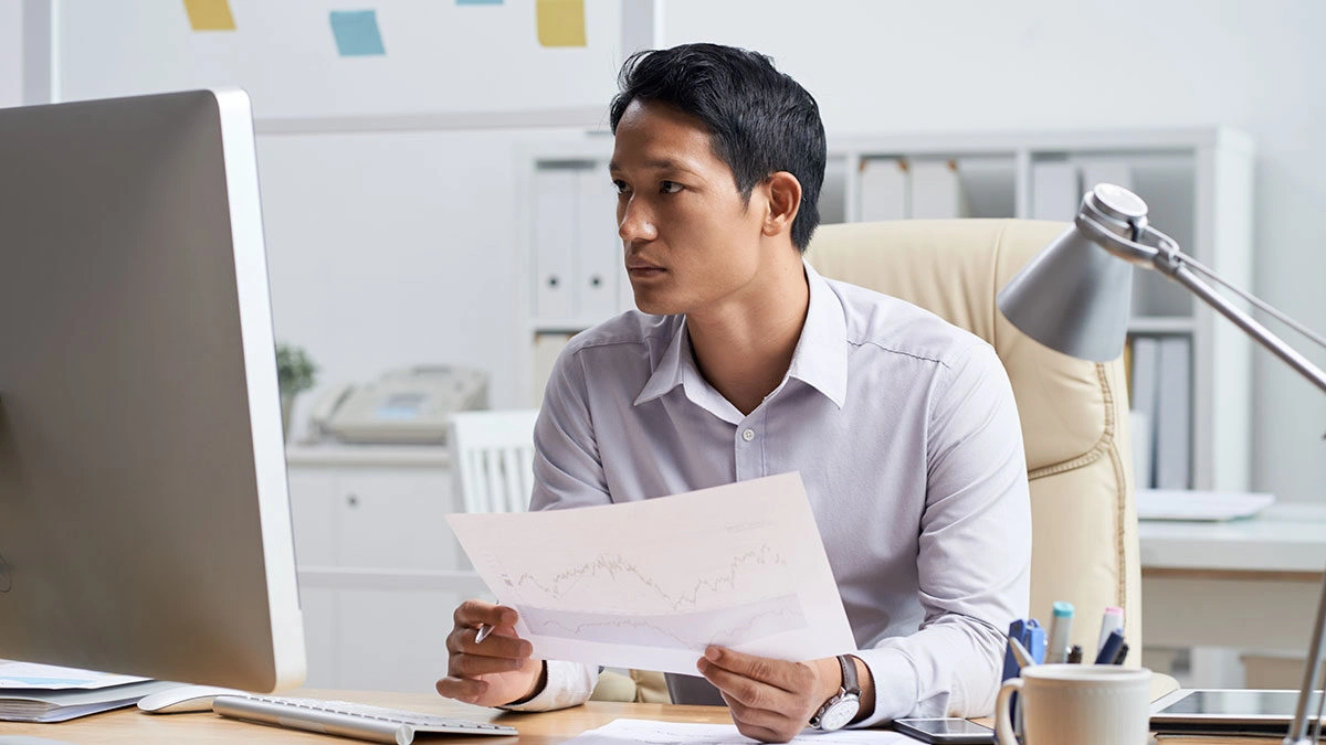 Malaysian business owner reviewing affordable web design options on laptop