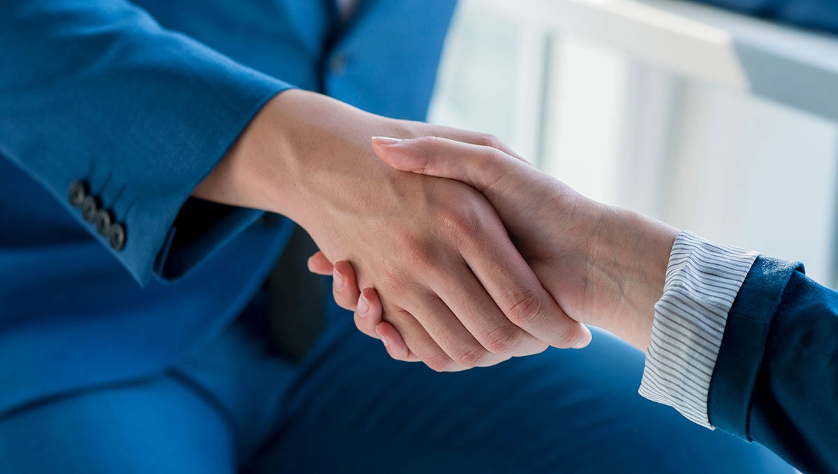 two business partners shaking hands office